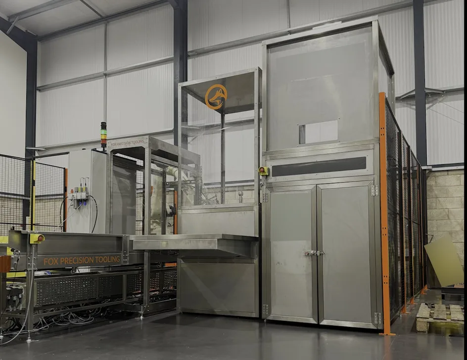 Finished turnkey robot cell on the workshop floor, fully guarded